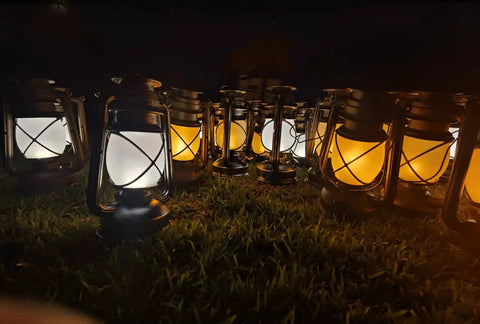 Bronze Outdoor LED Lantern With Vintage Flame Effect for garden and patio decor, multiple lanterns lit on grass.