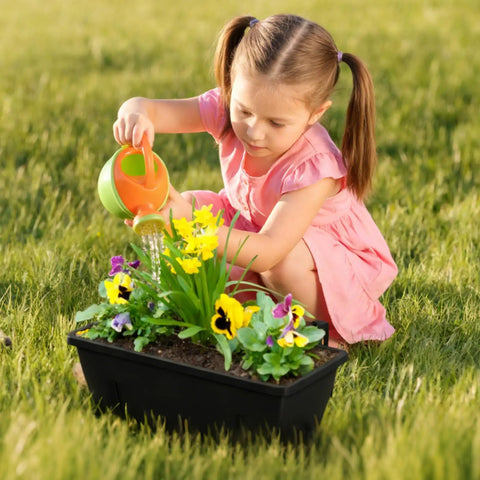 Child watering flowers in black planter box, part of Six Pack Railing Planter Boxes With Adjustable Brackets Black 17 Inch Deck Rail Planters.