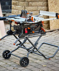 10 Inch Jobsite Table Saw With Wheeled Scissor Stand 15 Amp Motor Multi Material Cutting displayed outdoors on pavement.