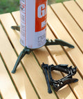 Durable Camping Cookware Canister Stand with Upgraded Nylon Build showing nonslip folding stove support on wooden table