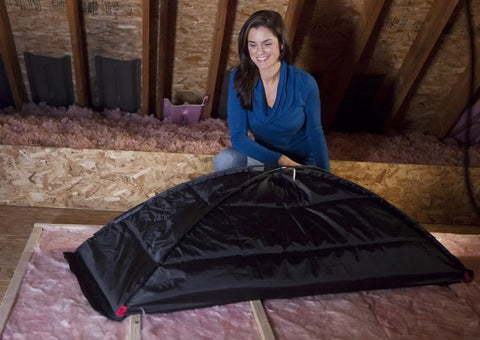 Person installing Stairway Attic Draft Cover for openings up to 25.5 by 54 inches, energy saving insulation shield for year round weatherization.