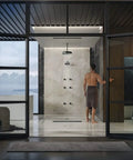 Modern bathroom with glass walls and a person near shower area demonstrates Anthem Digital On Off Remote Control For Shower System Sleek Wireless Button That Makes On And Off Actuation A Breeze For Handheld With Hose Tub Spout Or Fixed Shower Head functionality.