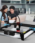Front view of Twotrees TTS-10 Pro laser engraver on a desk; black and blue frame with red laser module.