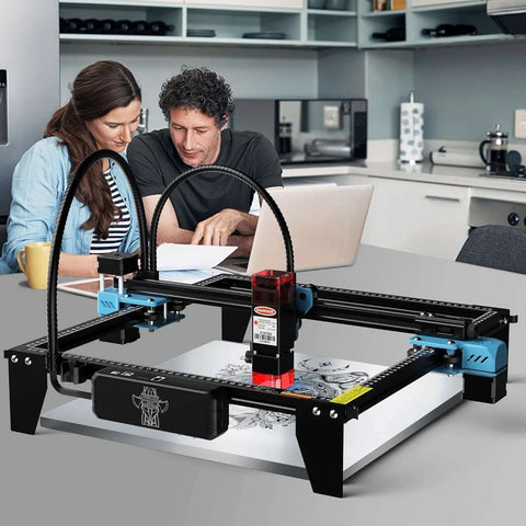 Front view of Twotrees TTS-10 Pro laser engraver on a desk; black and blue frame with red laser module.