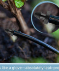Image of 100 Pack Drip Irrigation End Plugs for Quarter Inch Tubing installed in a garden, showing easy install line stopper fitting.