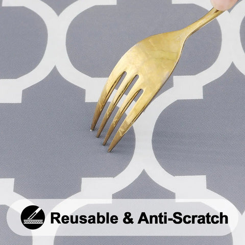 Close-up of gray and white design on round picnic tablecloth with fork showing anti-scratch feature, elastic edge windproof vinyl cover.