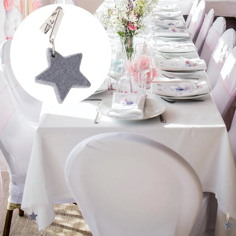 Eight Ounce Tablecloth Weights with Stainless Steel Clips for Outdoor Tables shown clipped to white cloth in bright setting, gray star detail