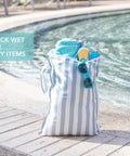 Big Waterproof Wet Bag Two Pack For Travel And Swim Gear by poolside, holding towels and sunglasses, gray and green stripe design