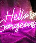 Pink LED Neon Sign Hello Gorgeous For Home Decor And Party Backdrops, 16.5x10.6 Inches, glowing on fabric background