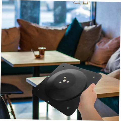 Hella Sturdy Heavy Duty Cast Iron Table Leg Mounting Plate Multi Connector held in hand, black material, used for furniture assembly.