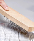 Person using a bristle brush on aluminum foil backing of Heavy Duty Self Adhesive Roof Repair Tape for effective sealing.