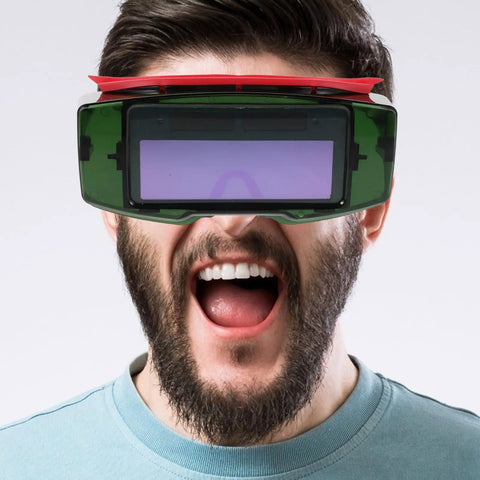 Top Shelf Auto Darkening Welding Goggles With Rugged Impact Resistant Lens For Hardcore Industrial And Garage Work Fast Trigger Shock Resistant Safety Specs on a man.
