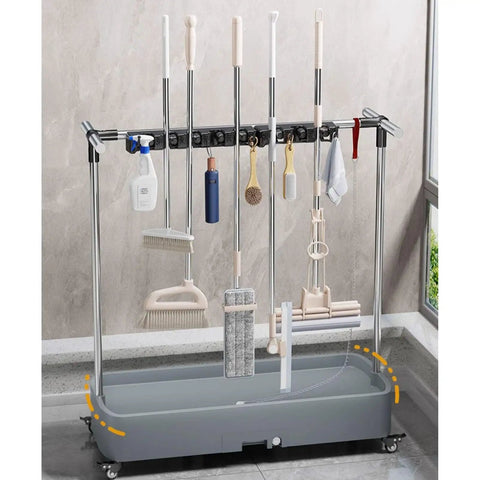 Heavy Duty Floor Mounted Mop Rack And Broom Holder With Stainless Steel Frame And Thick ABS Tray Pro Grade Garage Ready Storage Organizer holding various tools.