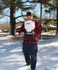 Man using 20 Pound Capacity Portable Chest Mount Spreader With Cross Shoulder Strap For Lawn Care And Garden Pros in snowy garden