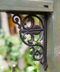Heavy Duty Iron Corner Braces Tough As Nails Floating Shelf Supports Wall Mounted Triangle Plant Stand Steel L Brackets Set Of Two close-up view of decorative iron corner brace with floral design