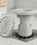 Odor Stopper for Shower - Anti-Odor Mini Bottle Trap Design in gray showing bottle trap and drain cover.