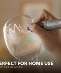 Dremel Stylo+ engraving pen hand-etching a glass goblet; silver tool