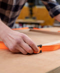 Person using Heavy-Duty Adjustable Band Clamp For Woodworking And Framing, 15-Foot Strap on a woodworking table