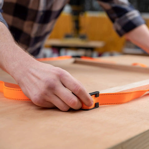 Person using Heavy-Duty Adjustable Band Clamp For Woodworking And Framing, 15-Foot Strap on a woodworking table