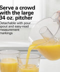 Hamilton Beach 34 Oz Electric Citrus Juicer With Silicone Gripper Lid Easy Press Juice Extraction Three In One Jar Opener And Storage Cover For Fresh Orange Lemon Grapefruit Squeezing Daily Kitchen Routine pouring juice into two glasses.