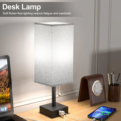 Gray Bedside Lamp With Dual USB Ports USB C And USB A For Nightstand Or Small Desk on a wooden desk with accessories.