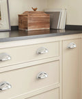 Ravino Polished Chrome Cabinet Cup Pull 3 Inch Center To Center Drawer Handle installed on cream cabinet drawers.
