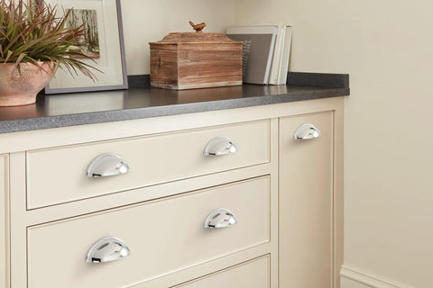 Ravino Polished Chrome Cabinet Cup Pull 3 Inch Center To Center Drawer Handle installed on cream cabinet drawers.
