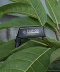 Osprey Flip G2 Dual Band RC FPV Antenna for 2.4GHz and 5.8GHz in gray, resting on green leaves, compact and foldable design.