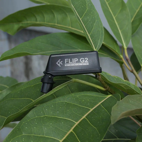 Osprey Flip G2 Dual Band RC FPV Antenna for 2.4GHz and 5.8GHz in gray, resting on green leaves, compact and foldable design.