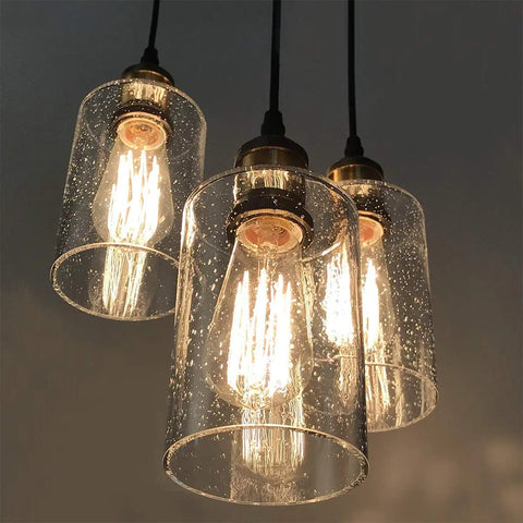 Three Light Black Pendant Light With Seeded Glass Shades, Modern Farmhouse Hanging Chandelier Fixture, illuminated view.