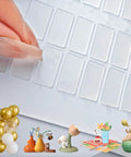 Hand removing a clear adhesive sheet from Super Grippy Removable Glue Dots For Diy Crafts And Home Decor Total Game Changer Formula.