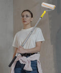Woman holding Best Selling Telescopic Paint Roller Brush With Detachable Extension Pole For Interior Doors Walls Quick Change Design.