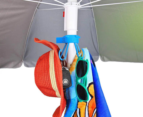 Stainless Steel Umbrella Hook For Beach Gear And Towel Bag Holder Keeps Sand Off Tables And Surfaces Patio Accessory Fits All Standard Umbrella Poles Includes Clear Adapter For Skinny Poles Made In USA Blue holding hat, keys, and towel under umbrella