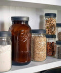 Leak-Proof Wide Mouth Mason Jar Lids, 6 Pack on jars filled with grains, nuts, and seeds on a shelf
