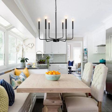 Rustic Matte Black 6 Light Candle Chandelier For Dining Room Kitchen Island Living Room And Foyer Industrial 26 Inch Ceiling Light Fixture Modern Farmhouse Style Black Chandeliers over dining table with windows in background.