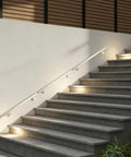 Hella Sturdy Stainless Steel Flush Handrail Wall Mounted For Indoor Stairs, sleek silver finish on lighted staircase.