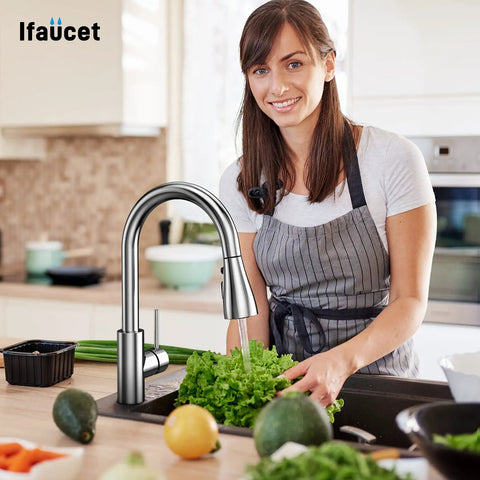 Smiling woman using Pull Down Kitchen Sprayer Head With Three Function Modes And Twelve Adapters For Universal Faucet Fit Chrome Finish