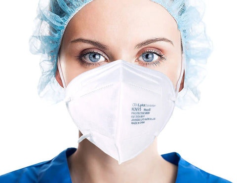 Person wearing Everyday KN95 Face Mask Pack for Adults and Kids With Five Layer Breathable Protection, blue cap visible.