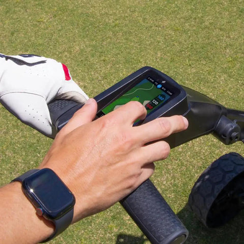 User interacting with touchscreen GPS on Slick Remote Controlled Electric Golf Push Cart Bundle with courses.