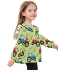 Ultra Soft Cotton Baby Girl Blouse With Ruffled Sleeves Featuring Farm Tractor Print On Green Background For Everyday, Holidays And School, Cozy Long Sleeve Top, Machine Washable, Easy Care 5T worn by a smiling child