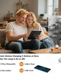 Couple using tablet next to Mountain Watercolor Bedside Table Lamp With 3-Way Dimmable Touch Control And Built-In Charging Station