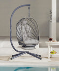 Cozy Outdoor Egg Swing Chair With Stand And Footrest Deep Cushioned Hammock Style Seat For Patio Or Indoor Use Waterproof Rattan Sturdy Metal Frame Comfy Lounge Chair In Dark Gray on a patio by a pool.