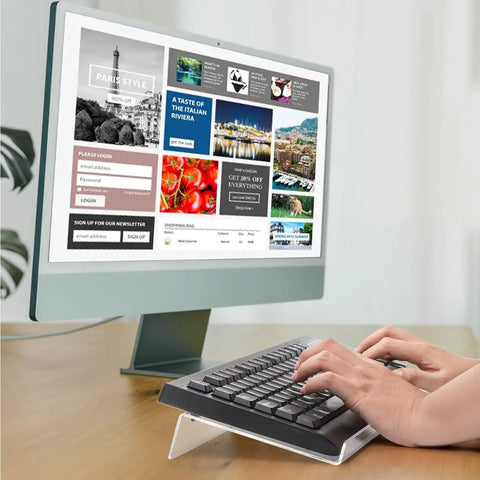 Person typing on a keyboard placed on a clear acrylic stand at 15° angle, part of the Two Pack Tilted Keyboard Stand In Clear Acrylic For Ergonomic Typing.