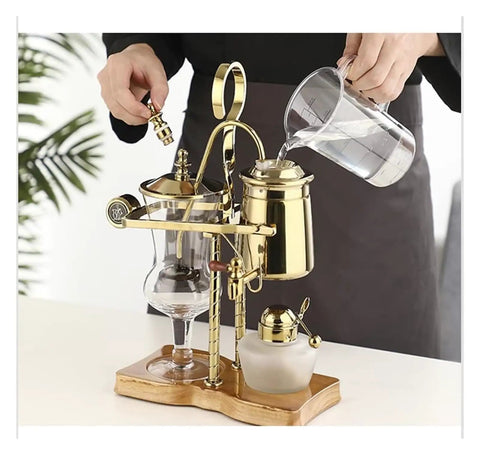 Top Shelf Siphon Coffee Maker Syphon Glass Brewer 4 Cup with gold accents and ergonomic handle, pouring water for brewing.