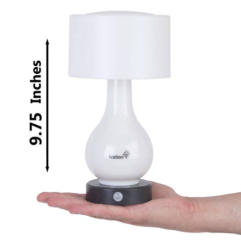 Person holding a 9.75-inch Six LED Battery Operated Motion Sensing Table Lamp With Dual Zone Lighting for size reference