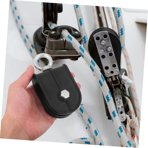 Hand holding Heavy Duty Pulley Block Built Tough With Silent Rotating Wheel For DIY Home Gym Cable Systems Swivel Lifting Pulleys That Run Smooth Detachable Roller Wheel For Easy Setup And Smooth Operation, black metal