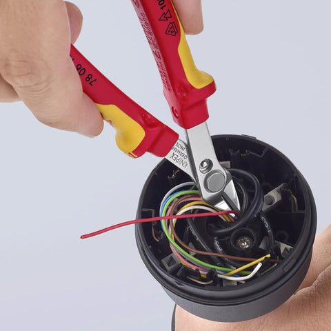 Insulated 5 Inch Diagonal Cutting Pliers With 1000V VDE Rating cutting wires in an electrical component, flush cut precision visible.