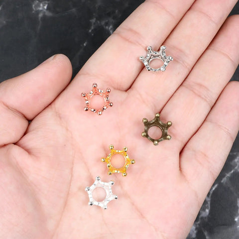 60 Piece Crown Charms Set For Jewelry Making With Six Vintage Colors 3D Alloy Crown Beads displayed on a hand