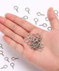 Close-up of hand holding Heavy Duty Screw Eye Hooks 0.63 Inch 300 Pack Durable Iron Eye Screws for Hanging Artwork and indoor outdoor use
