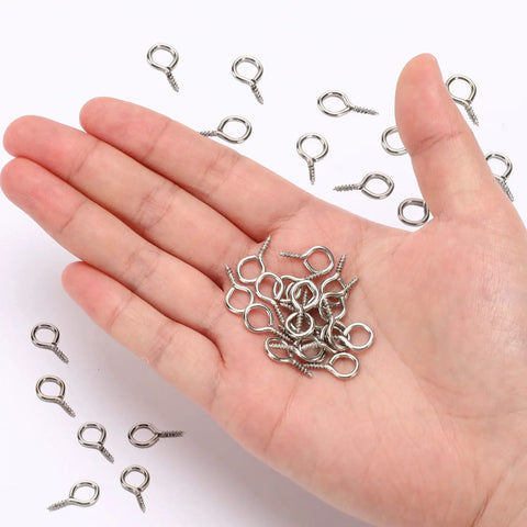 Close-up of hand holding Heavy Duty Screw Eye Hooks 0.63 Inch 300 Pack Durable Iron Eye Screws for Hanging Artwork and indoor outdoor use